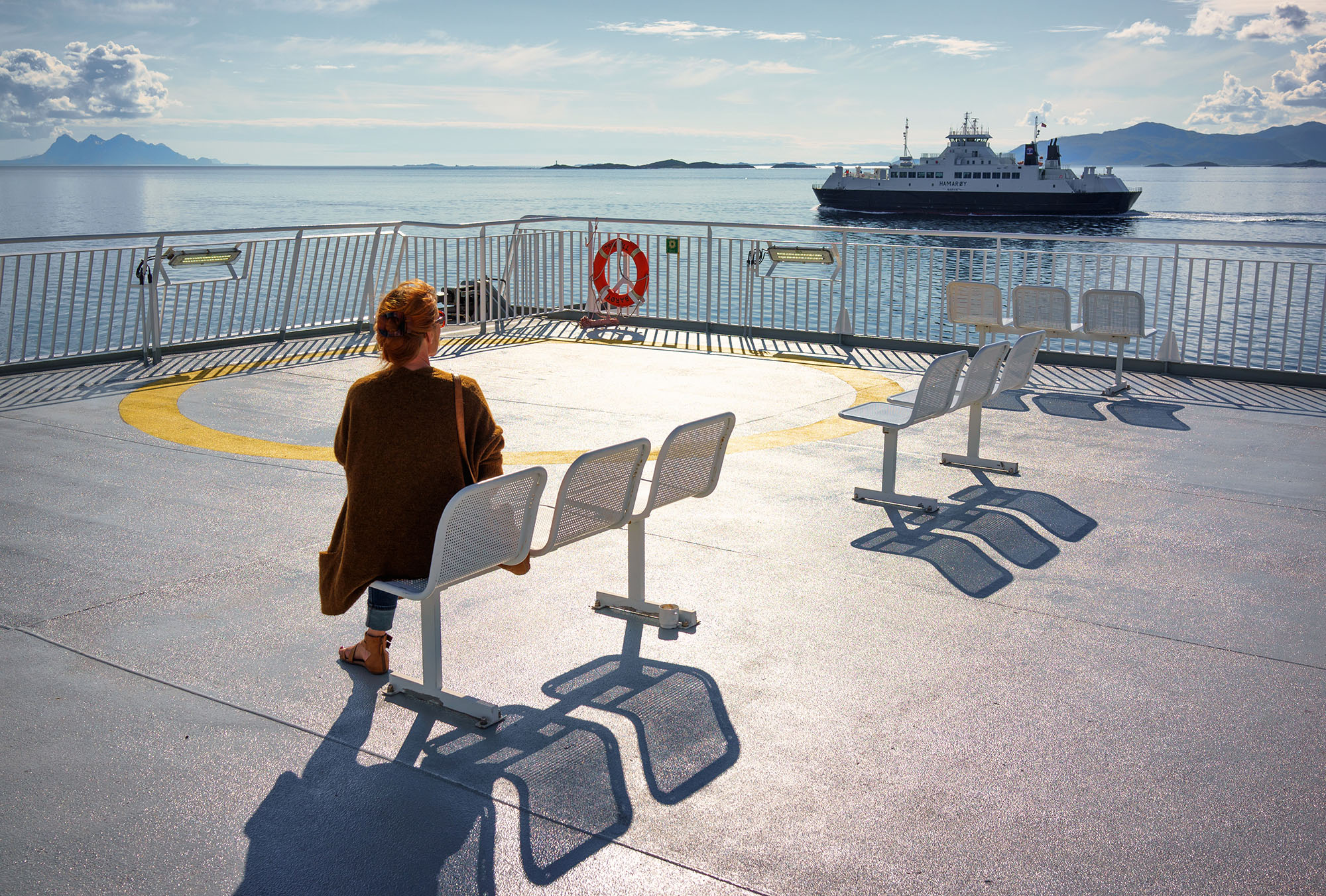 Une femme assise de dos sur un banc prête à partir en voyage